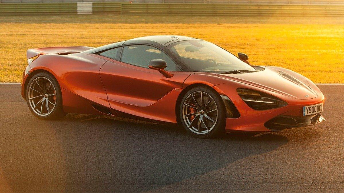 An orange McLaren supercar at sunset