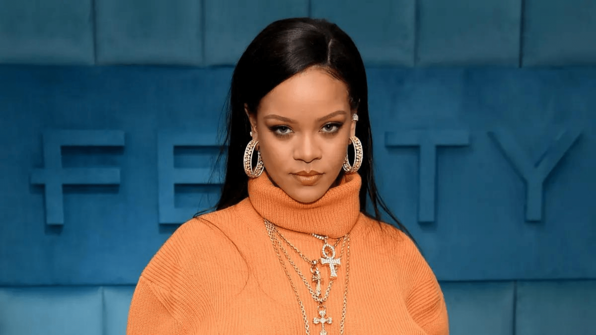 rihanna in orange with blue background