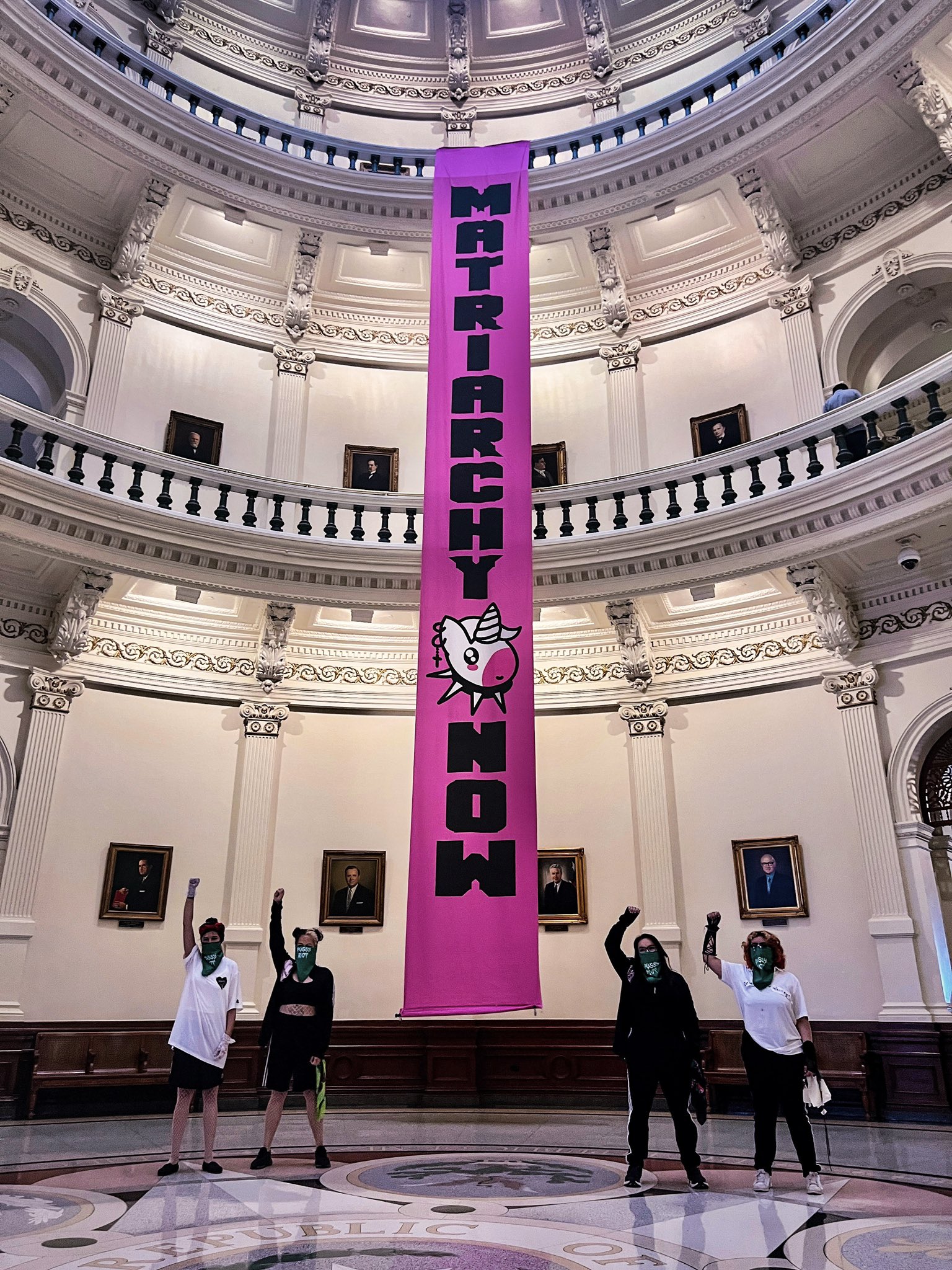 Matriarchy Now banner with Pussy Riot members standing in front